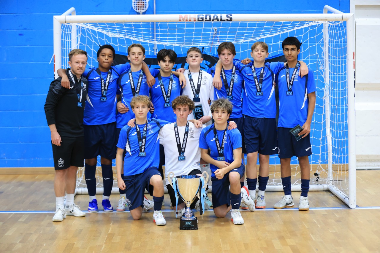 Braintree’s Under-16 squad and coach pose with their medals and the TFC trophy. Photo: @mediaplusuk.